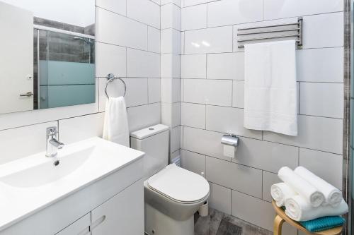 une salle de bain blanche avec toilettes et lavabo dans l'établissement Faro Guest House, à Faro