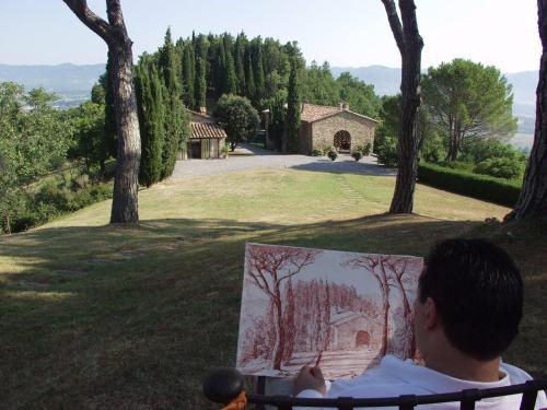 a man sitting on a bench looking at a painting at Podere Capitignano in Borgo San Lorenzo