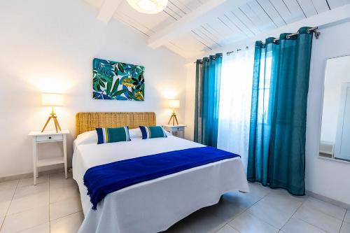 une chambre avec un grand lit avec des rideaux bleus dans l'établissement Faro Guest House, à Faro
