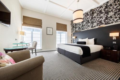 a hotel room with a bed and a couch and a table at Boutique Hotel Notting Hill in Amsterdam