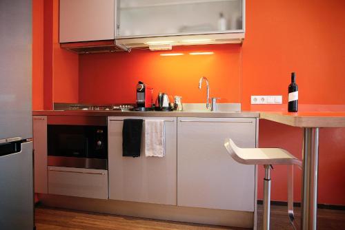 a kitchen with orange walls and a sink and a counter at Prinsenhuis in Amsterdam
