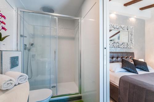 a bathroom with a shower and a bed and a toilet at Villa Fema in Rovinj