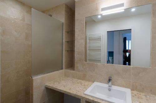 une salle de bain avec un lavabo et un miroir dans l'établissement Quiet apartment near Montmartre, à Paris
