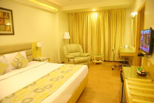 a hotel room with a bed and a chair at Royal Fort Hotel in Visakhapatnam