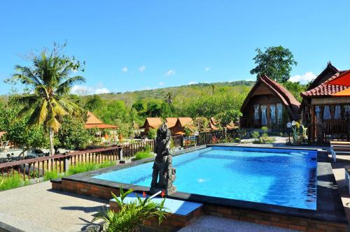 a swimming pool at a resort with a house at Surya Chandra Beach Bungalow in Nusa Penida