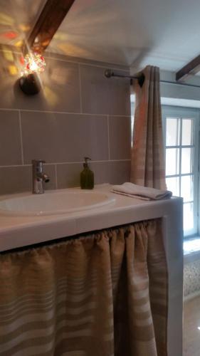 une salle de bain avec un lavabo et une fenêtre dans l'établissement Le Moulin de l'Ostriconi, à Novella