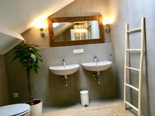 a bathroom with two sinks and a mirror on the wall at Morgentau Penthouse in Passau