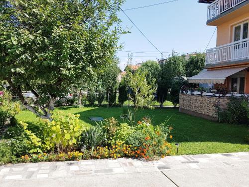 a garden with flowers and a house at Guesthouse Relax and Fly Sarajevo in Sarajevo