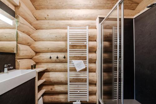 a bathroom with a wooden wall and a shower at Clofers Leisure Lodges Jenig in Jenig