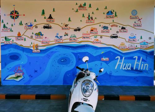 a scooter parked in front of a wall with a mural at KK Garden 小院 in Hua Hin