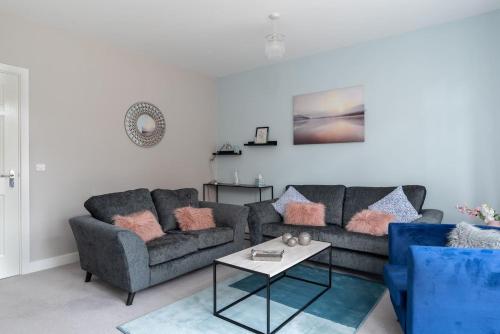 a living room with a couch and a table at Ashland House in Milton Keynes