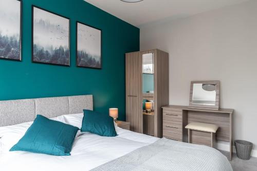 a bedroom with a bed and a blue wall at Ashland House in Milton Keynes