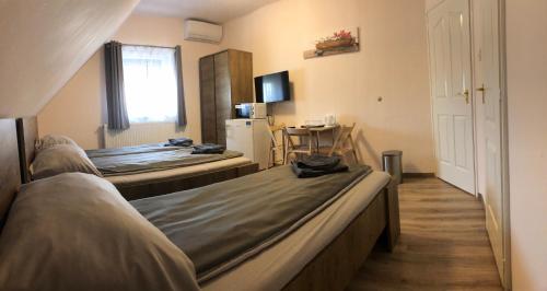 una camera d'albergo con due letti e un tavolo di Fitt Panzió a Sásd