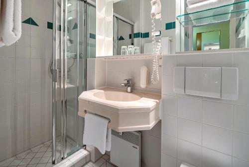 ein weißes Badezimmer mit Waschbecken und Dusche in der Unterkunft AHORN Panorama Hotel Oberhof in Oberhof
