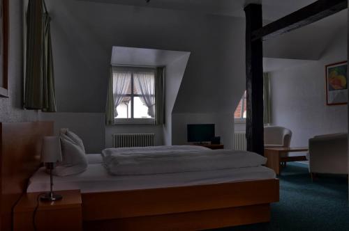 um quarto com uma cama grande e uma janela em Hotel Alte Linden em Altena