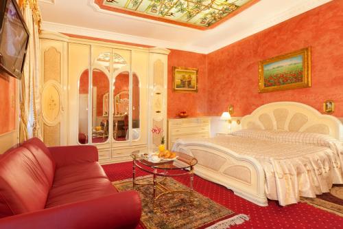 a bedroom with a bed and a couch and a table at Hotel Victoria in Lugano