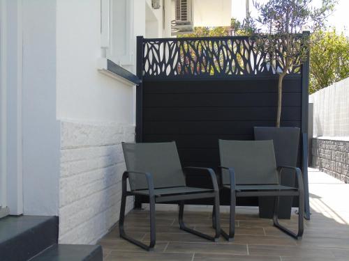 two chairs sitting on a patio next to a fence at Vllla Reva in Argelès-sur-Mer