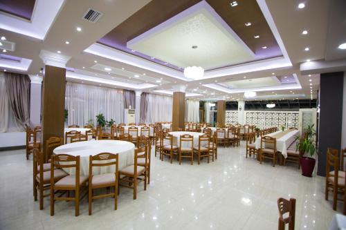un salón de banquetes con mesas y sillas en DEA Hotel 2002, en Korçë
