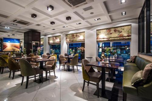 - un restaurant avec des tables, des chaises et un canapé dans l'établissement Boutique Hotel Notting Hill, à Amsterdam