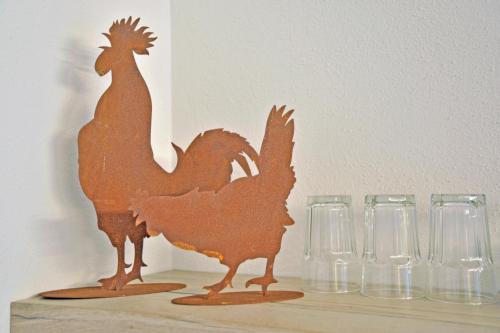 a wooden chicken sitting on a table next to glasses at Ca di Cetta in Finale Ligure