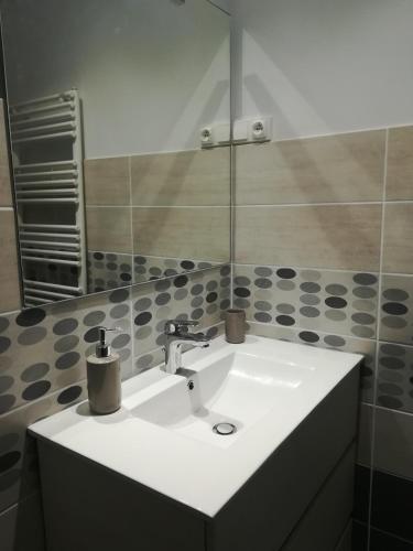 un lavabo blanc dans une salle de bain avec un miroir dans l'établissement Maison à la ferme, à Saint-Aubin-le-Monial