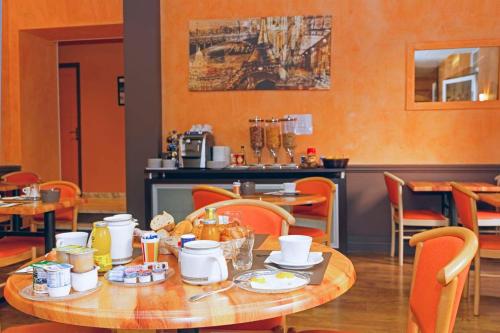 a dining room with a table with food on it at Hôtel du Vigan in Albi