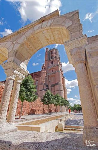 an archway in front of a building with a tower at Hôtel du Vigan in Albi