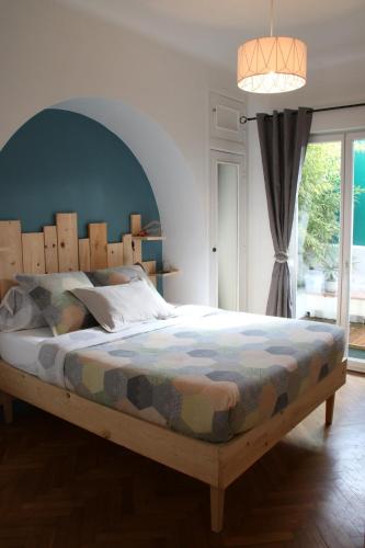 une chambre avec un grand lit avec une tête de lit en bois dans l'établissement 6 bedrooms seaview house, Old Town, à Nice