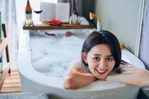 a woman laying in a bath tub at Yakamoz Haijie Hotel in Dali