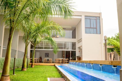 ein Haus mit einem Pool und Palmen in der Unterkunft Le Elementos Boutique Hotel in Lusaka