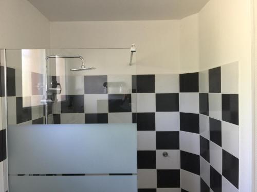 a bathroom with a black and white checkered wall at Jolie halte normande in Balines