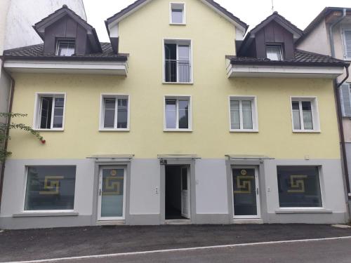 a yellow and white house with windows at 3 Doppelbett Business Apartment am Bodensee in Arbon