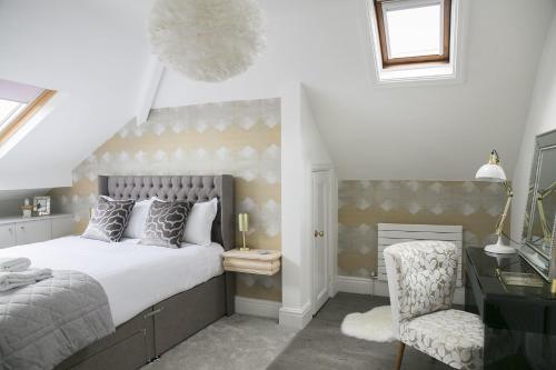 1 dormitorio con cama, escritorio y silla en Sanderson Suites en Harrogate
