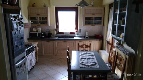 une cuisine avec une table et une cuisinière ainsi qu'une fenêtre dans l'établissement Residenza Montevile di Spaccini Gabriella, à Ponte San Giovanni