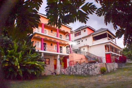 a large house with pink doors and windows at Boutique B&B at Stone Village in Bluefields