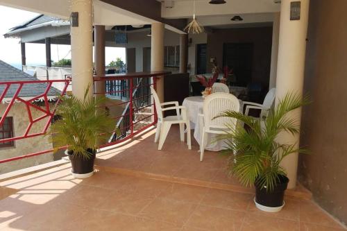 a balcony with a table and chairs and a table and chairs at Boutique B&B at Stone Village in Bluefields