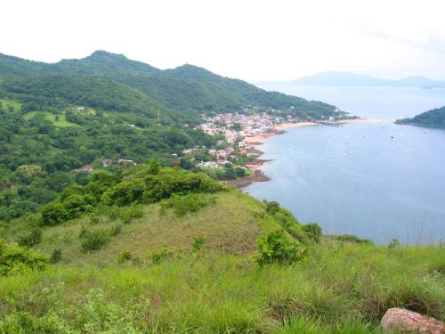 a view of a beach with a town and the ocean at Cerrito Tropical Eco Lodge in Taboga
