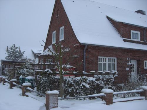 a red brick house with snow on it at Hus Nordhauk in Borkum