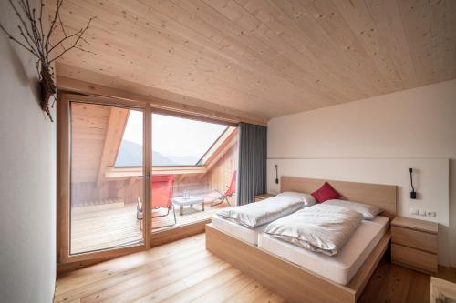 um quarto com uma cama e uma grande janela em Kristplonerhof em Bolzano