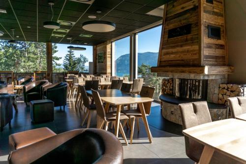 un restaurante con mesas y sillas y una chimenea en Village Club Les Balcons du Lac d'Annecy - Neaclub en Sévrier
