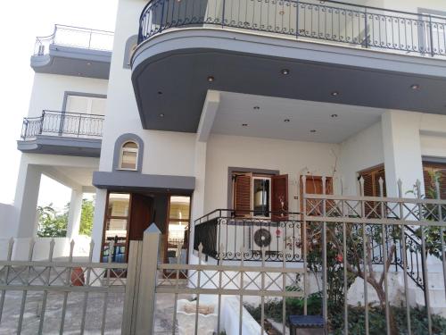 a large white building with a balcony on top at Dora's Apartment 5 min from airport in Spata