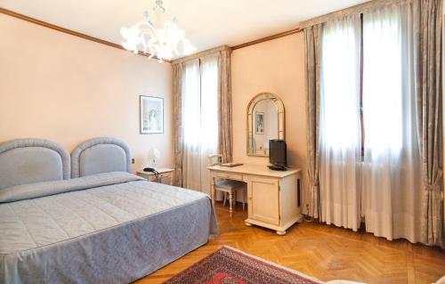 a bedroom with a bed and a table with a mirror at Park Hotel Villa Giustinian in Mirano