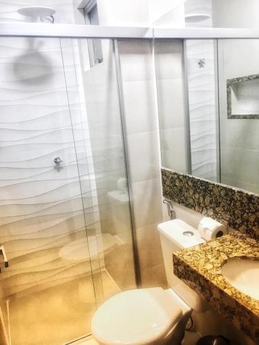 a bathroom with a shower and a toilet and a sink at Paradise Temporada Cobertura 4 Quartos com Jacuzzi e Churrasqueira no Thermas Paradise - Rio Quente in Rio Quente