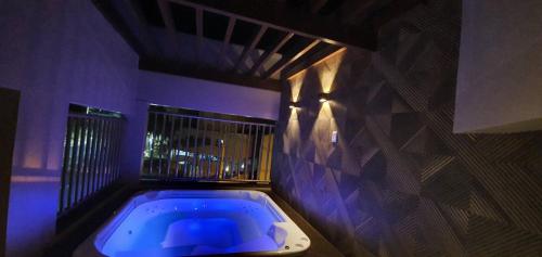 a bath tub in a room with purple lighting at Paradise Temporada Cobertura 4 Quartos com Jacuzzi e Churrasqueira no Thermas Paradise - Rio Quente in Rio Quente