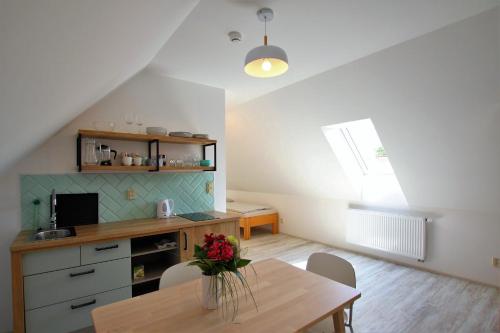 a kitchen with a table with a vase of flowers on it at Penzion U Kapličky in Znojmo