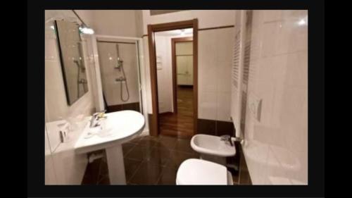bagno con 2 lavandini, servizi igienici e specchio di New Studio Città Studi a Milano