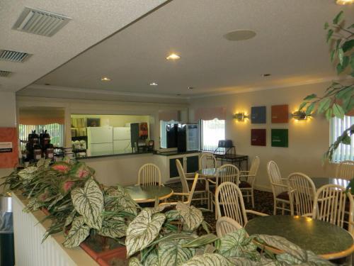 a restaurant with tables and chairs and a kitchen at Fairview Inn & Suites Mobile in Mobile