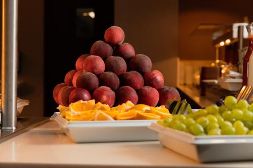 a pile of fruit on a plate on a table at Gradiali Wellness and SPA in Palanga