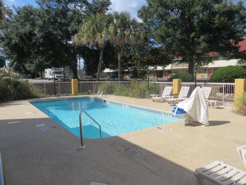 a swimming pool with two lawn chairs and a table at Fairview Inn & Suites Mobile in Mobile