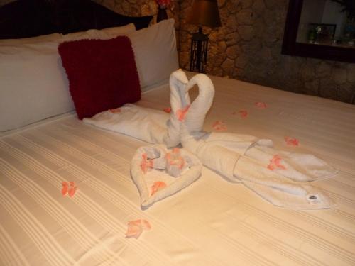 a bed with two swans made out of towels at Boutique B&B at Stone Village in Bluefields